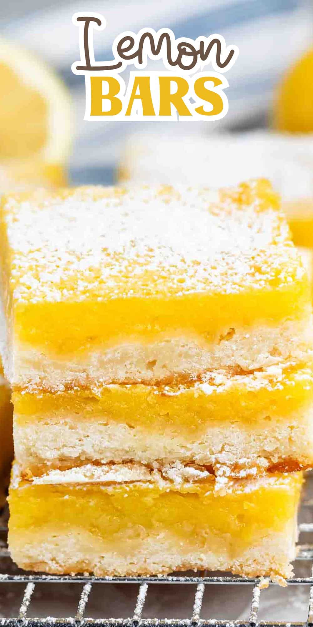 Close-up of three stacked lemon bars on a wire rack. The bars have a golden crust with a bright yellow lemon filling, topped with powdered sugar. A lemon is blurred in the background, with Lemon Bars text above.